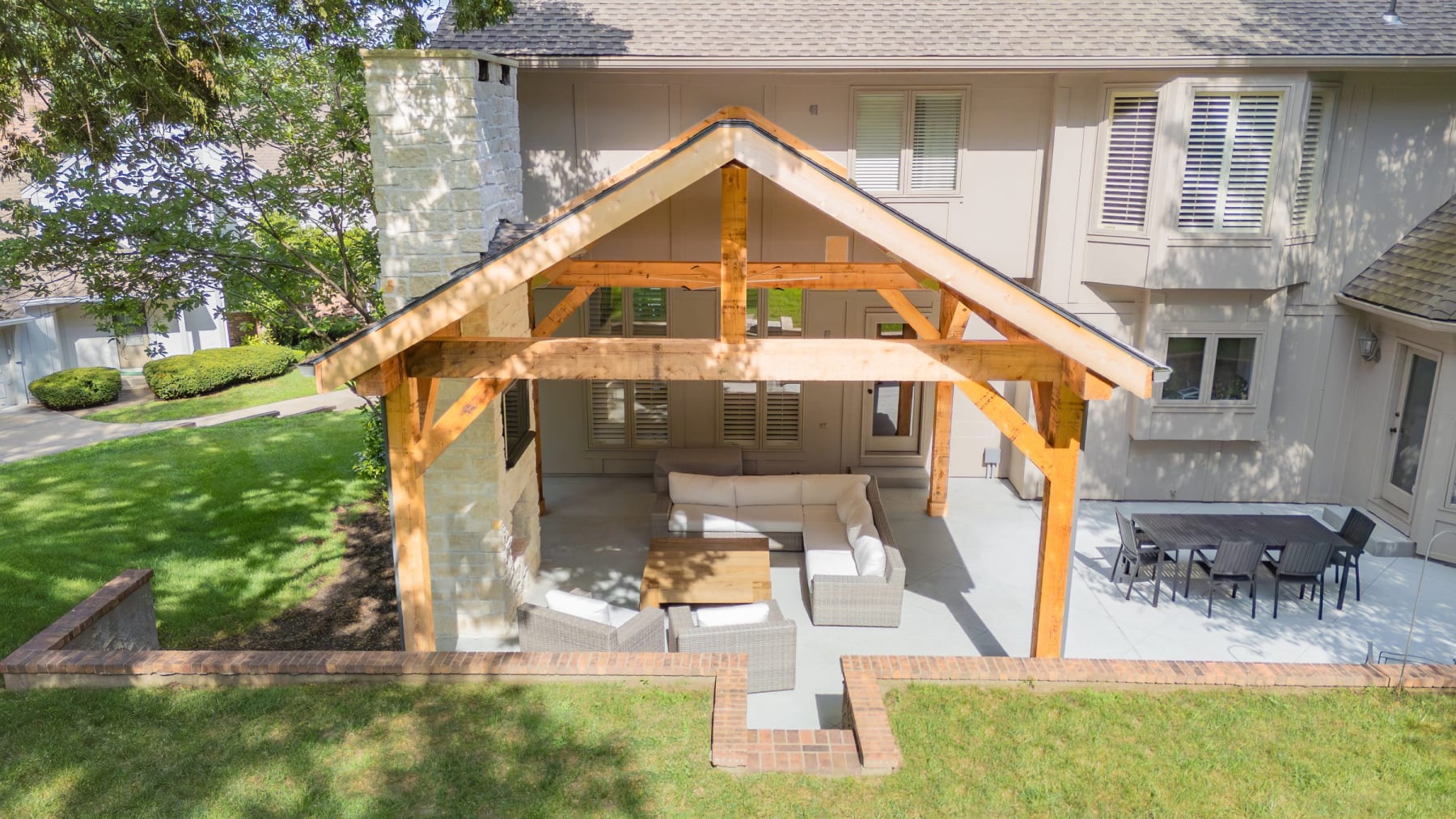 Aerial view of an outdoor living build with pavilion, fireplace, and paver patio by Kansas City Hardscapes