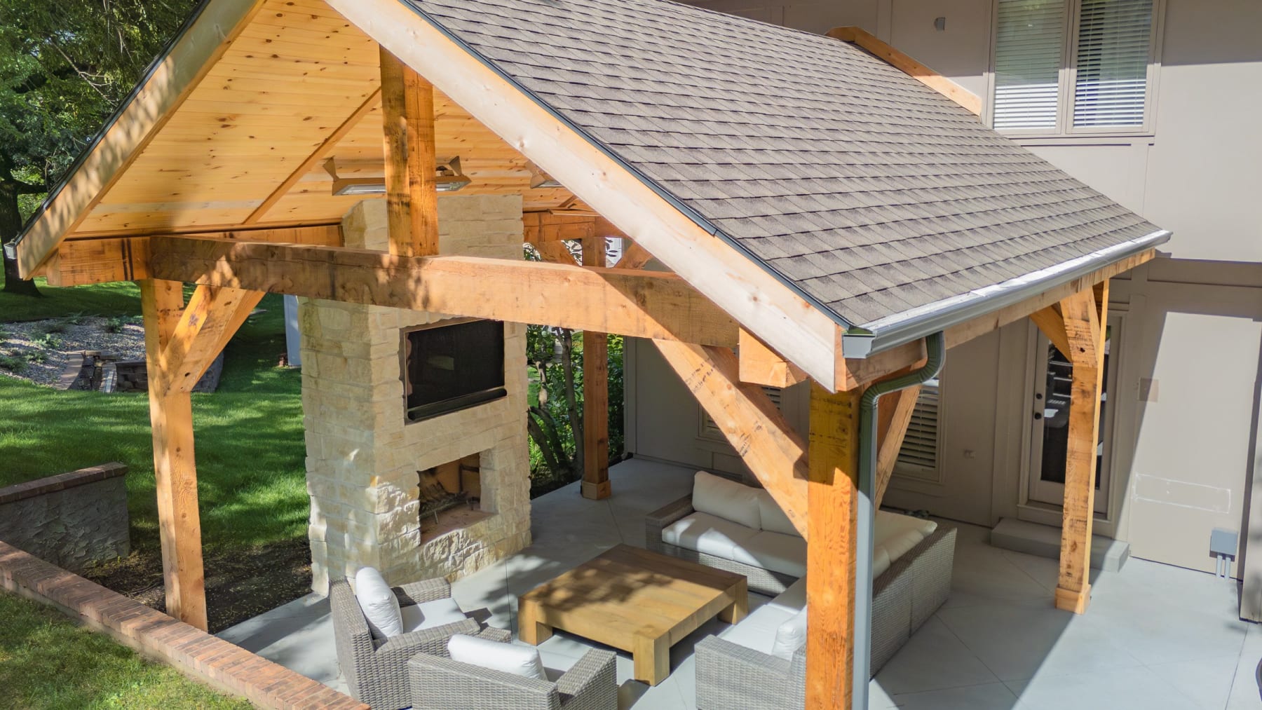 Aerial drone view of an outdoor living build with pavilion, fireplace, and paver patio by Kansas City Hardscapes