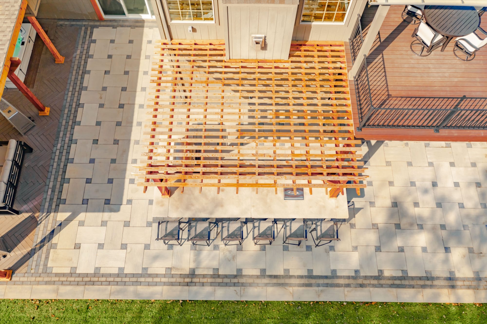 An aerial view of the finished Gerstner build: paver patio, pergola, bar seating, and upper deck