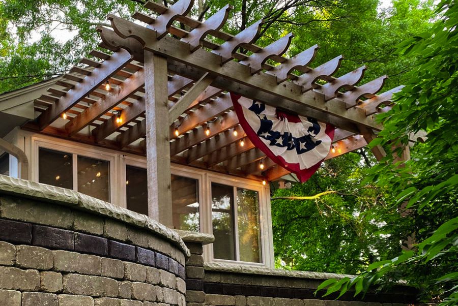 Cedar pergola with string lights and patriotic bunting
