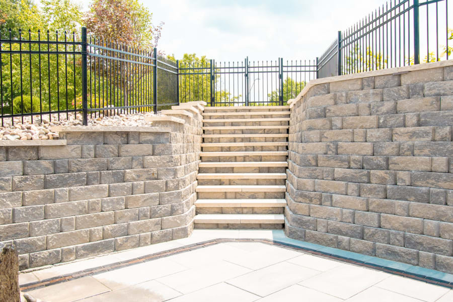 Travertine patio with paver retaining wall along the pool edge