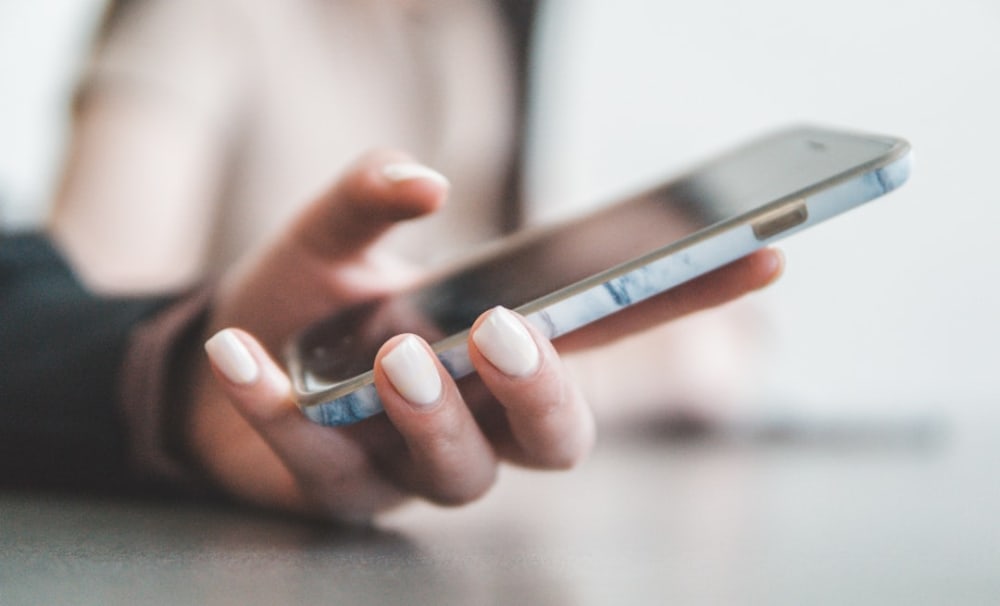 Gros plan sur les mains d'une personne tenant un smartphone