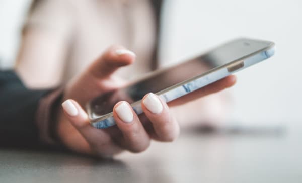 Gros plan sur les mains d'une personne tenant un smartphone