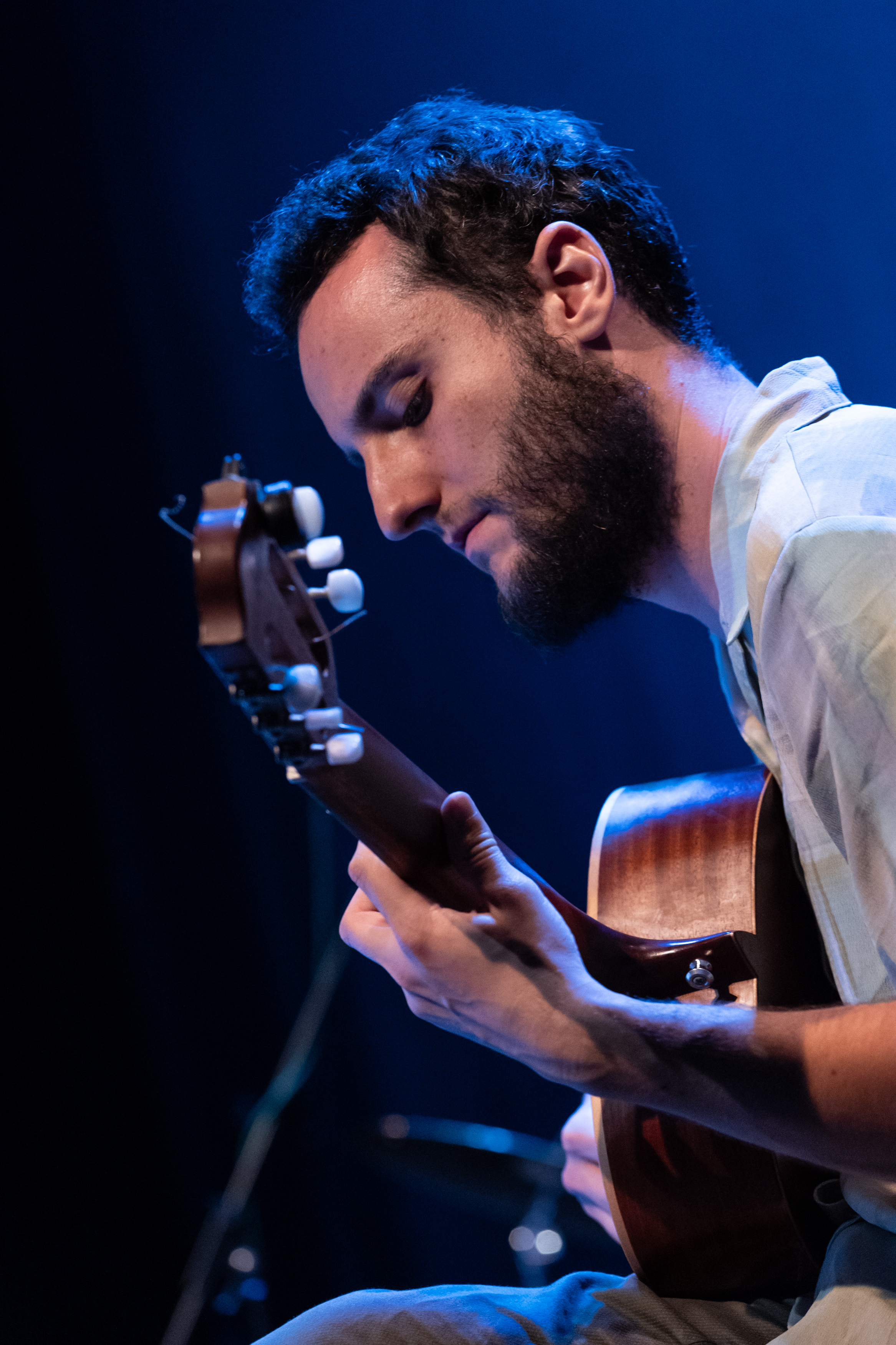 A professional portrait of a musician holding a guitar.