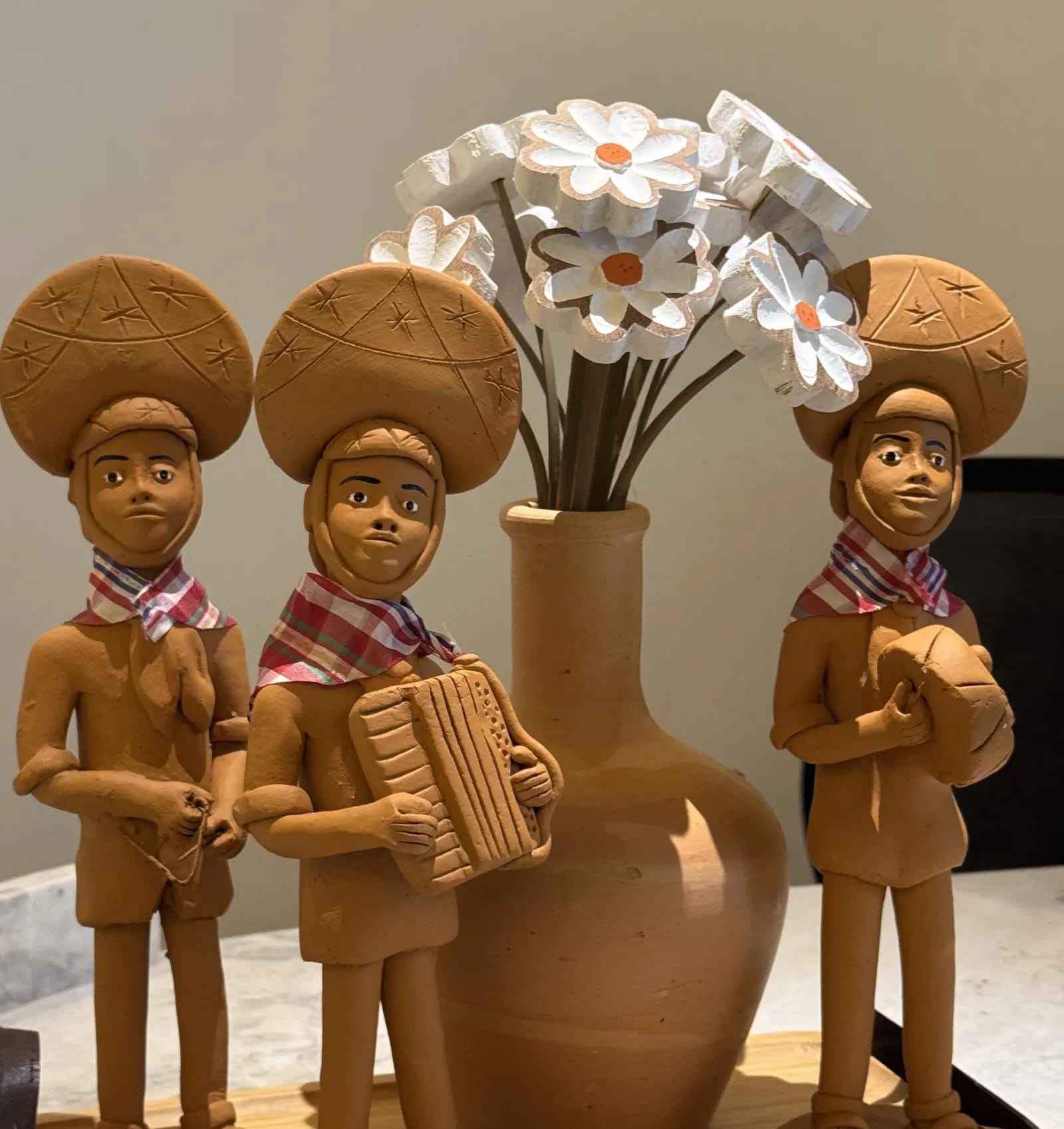 Trio de forró em barro, artesanato nordestino sobre o balcão da recepção