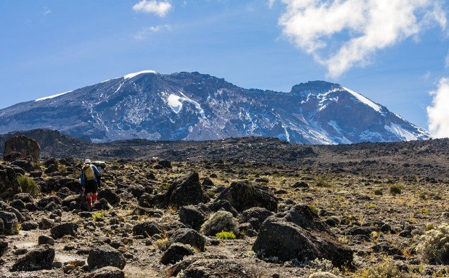 Climbers reaching Uhuru Peak at sunrise above the clouds