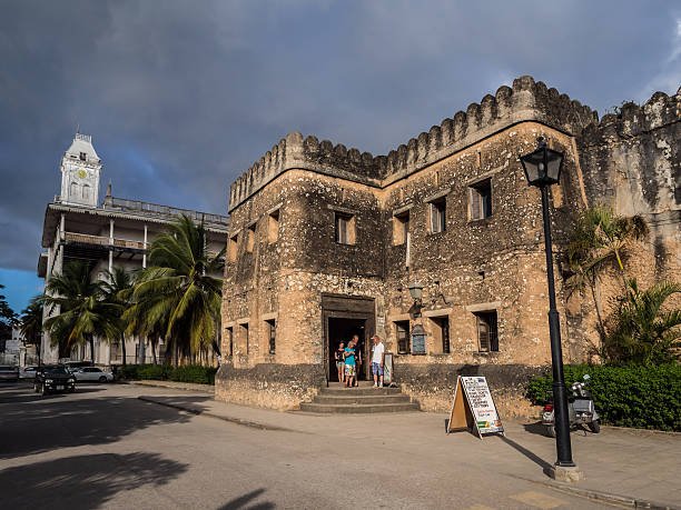 Historic Stone Town alley with carved doors, local market atmosphere, and Swahili architecture