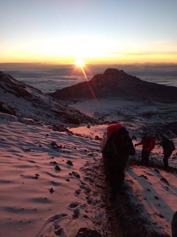 Climbers approaching Uhuru Peak during sunrise summit attempt on Kilimanjaro