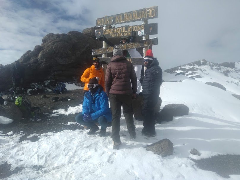 Snow and sunrise conditions near Uhuru Peak summit sign
