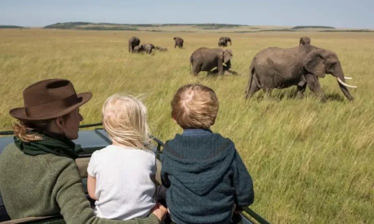 Family relaxing at a luxury safari lodge overlooking the African savannah