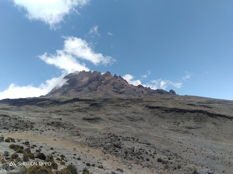 Trekkers hiking the Marangu Route on Mount Kilimanjaro with Mawenzi Peak in the background