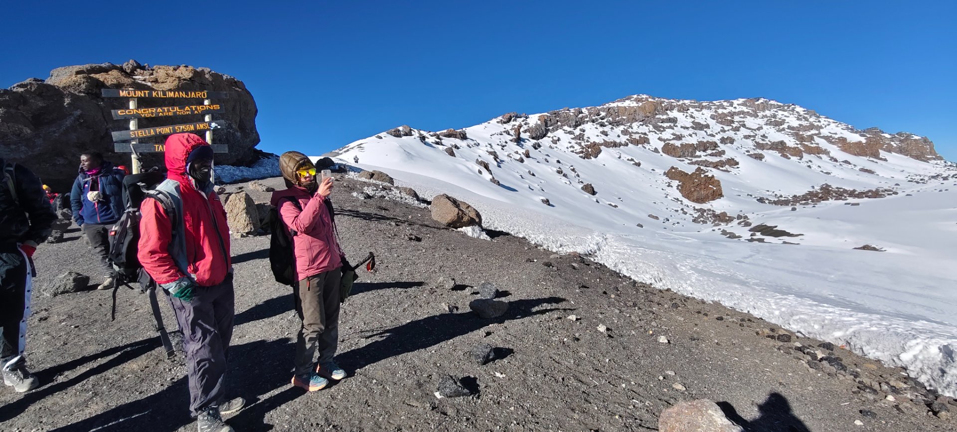 Climbers hiking at high altitude near Uhuru Peak during sunrise