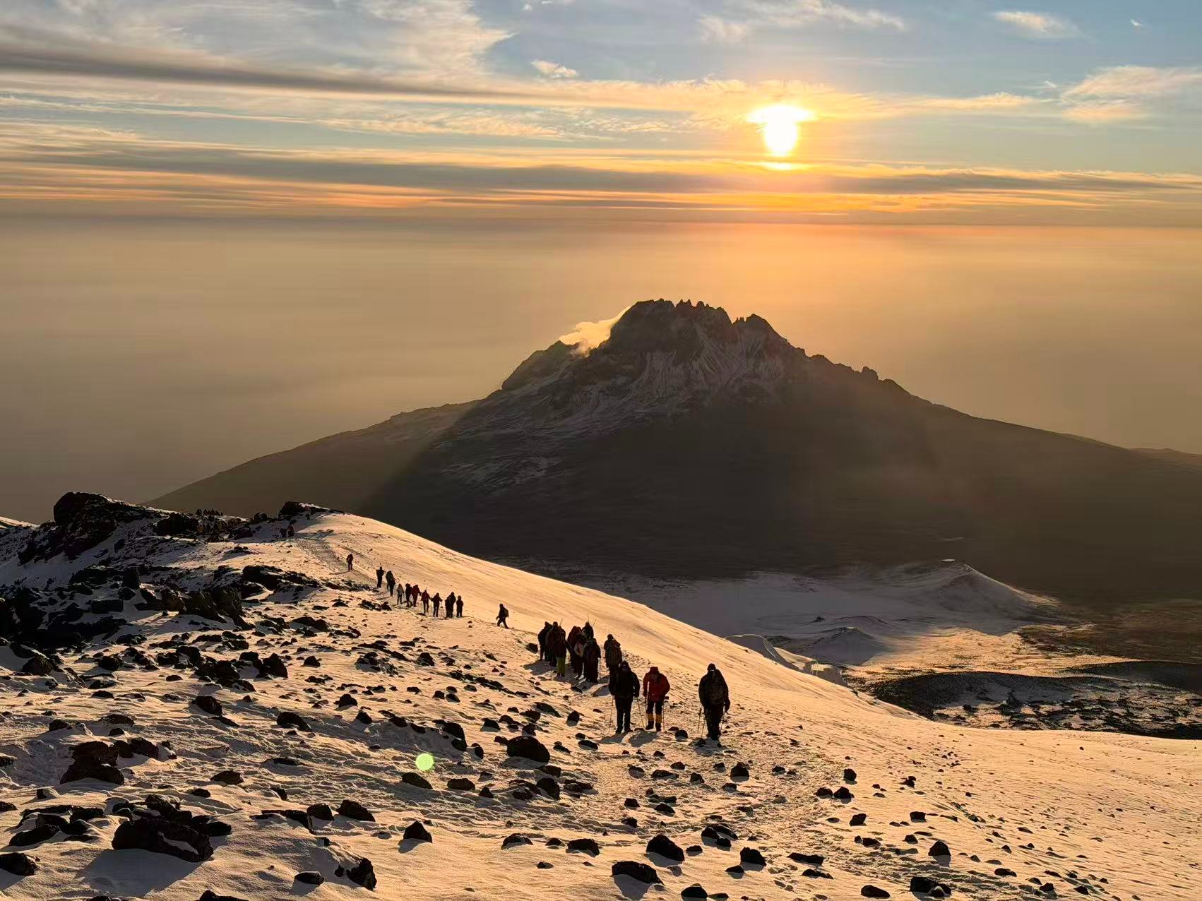 Climbers approaching Uhuru Peak on Mount Kilimanjaro during sunrise