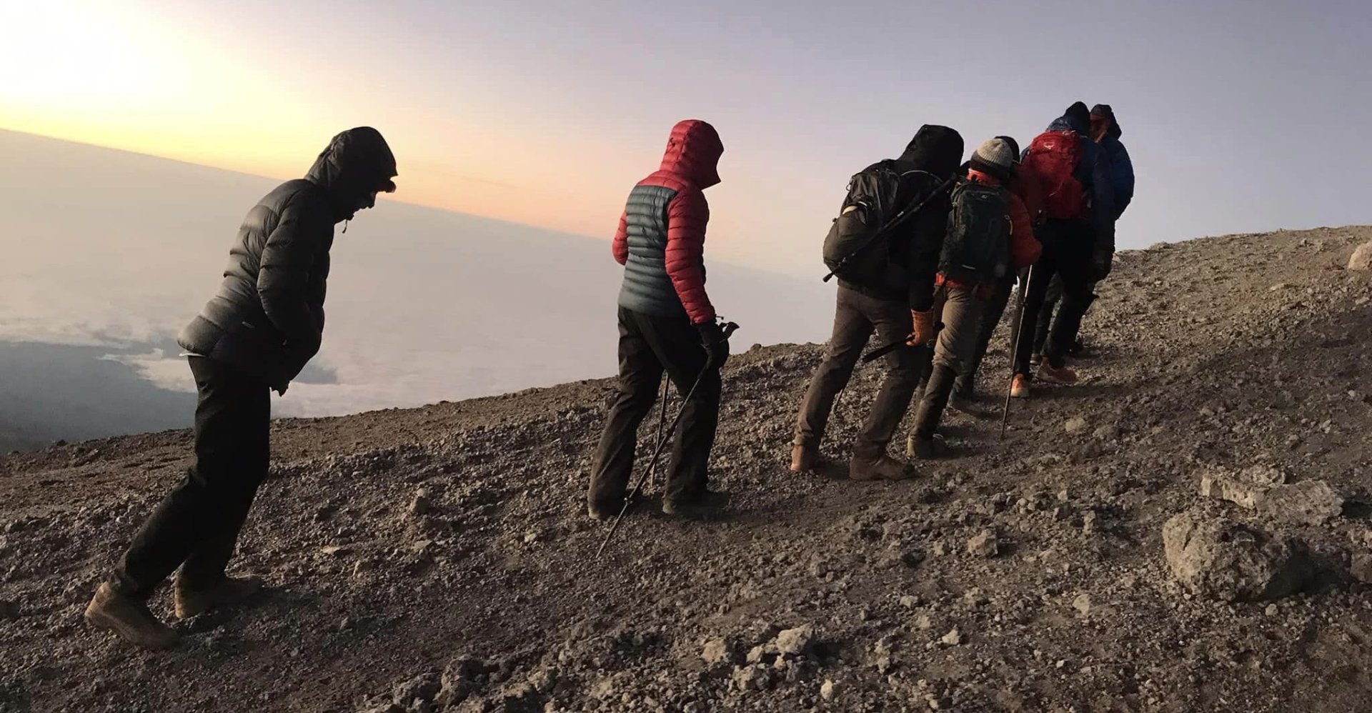 Climbers reaching Uhuru Peak during sunrise on Mount Kilimanjaro