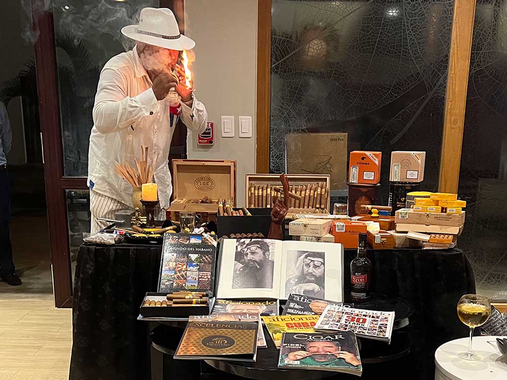 Man lighting cigar in Cuba with pictures of cigars