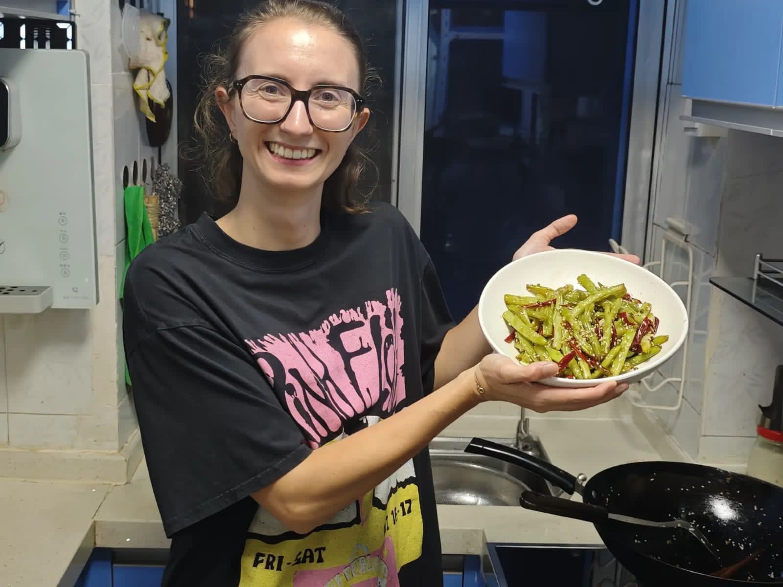 A guest holding the dish she cooked in Karen's class