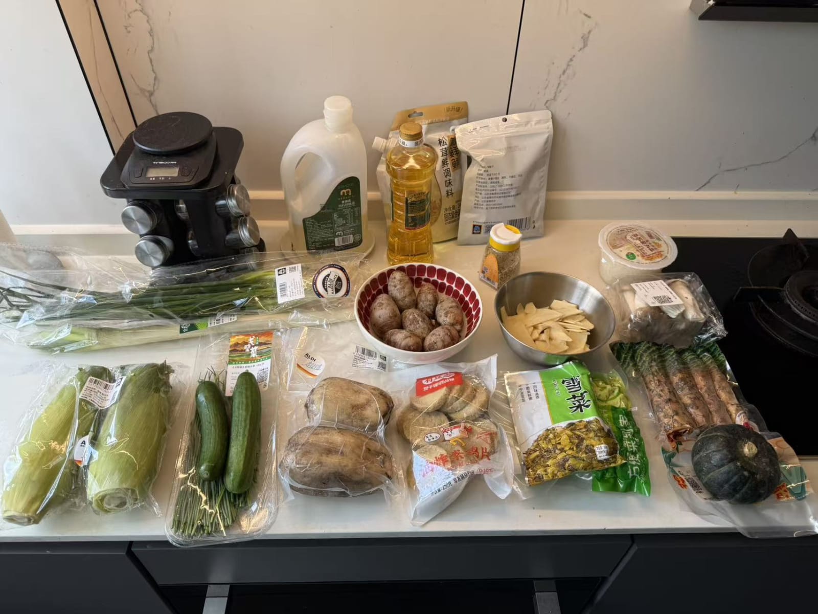 A full counter of vegetables, aromatics and pantry ingredients prepared for the class