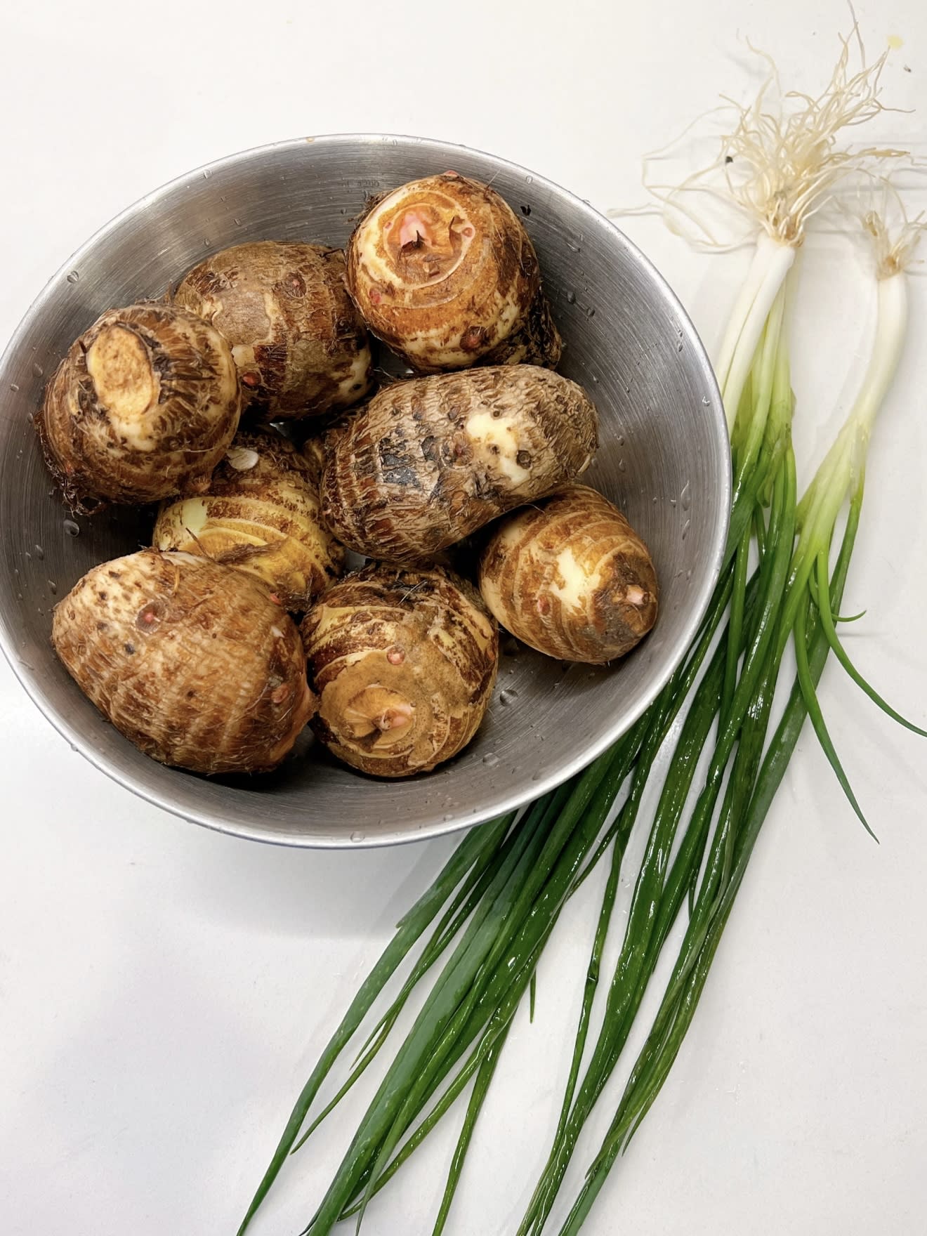 Fresh taro and spring onions ready for cooking