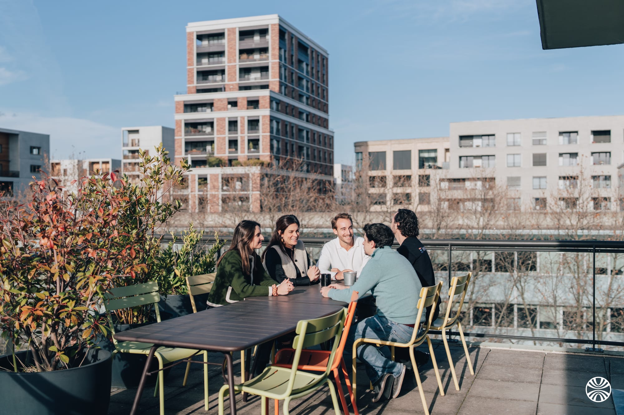 Finthesis team members discussing around a table on a terrace