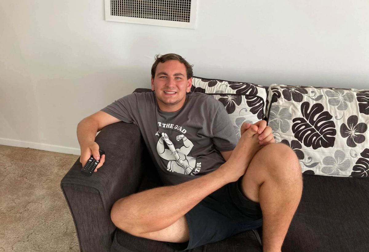 Man relaxing on a couch smiling.