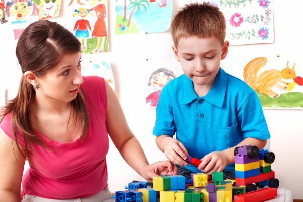 Child playing with legos with parent