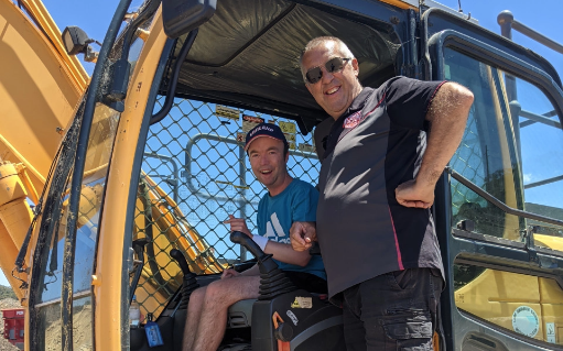 an Everyday Ability Worker standing with a client in a large industrial machine.