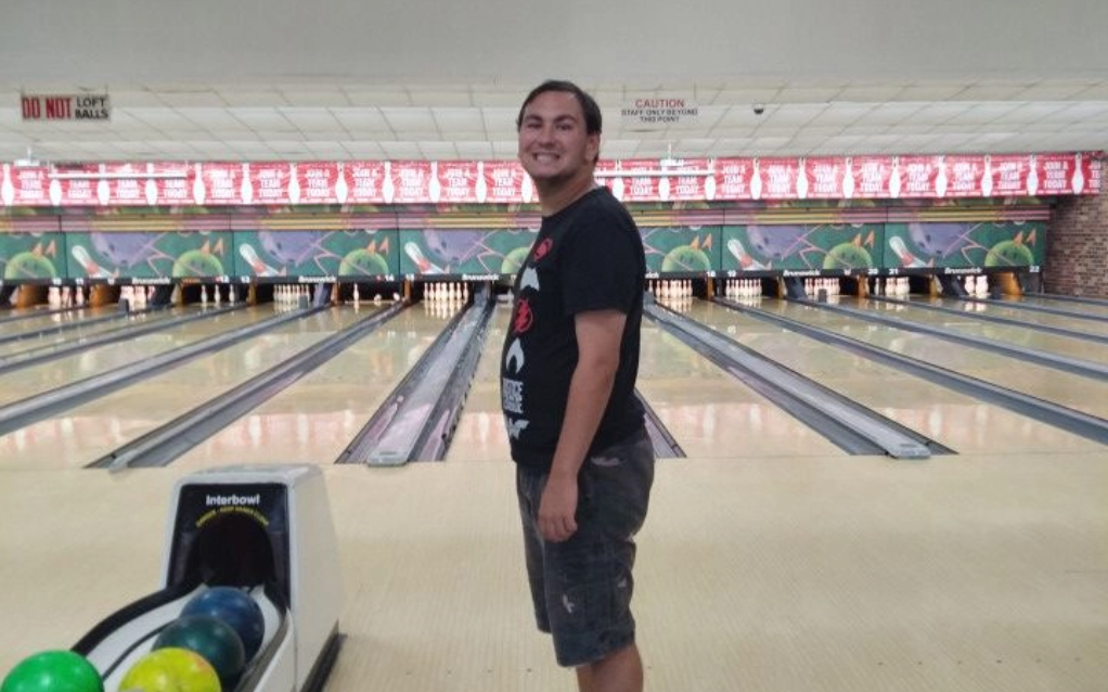 A man smiling while bowling