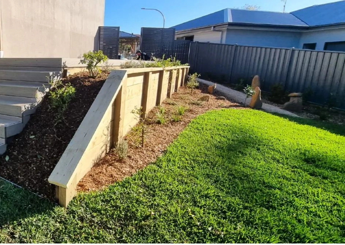 a small garden with steps leading up to a house