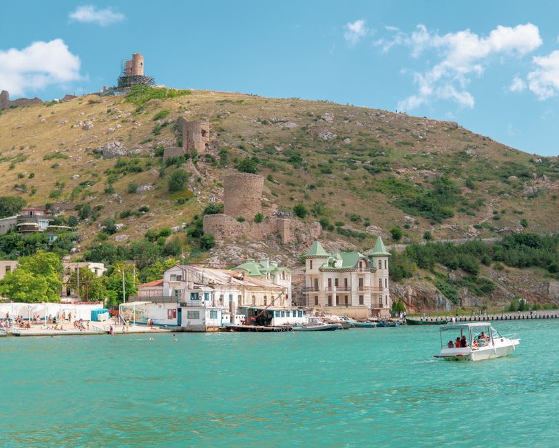 Les murailles de la forteresse génoise de la vieille Foça s'élevant au-dessus du petit port de pierre au crépuscule