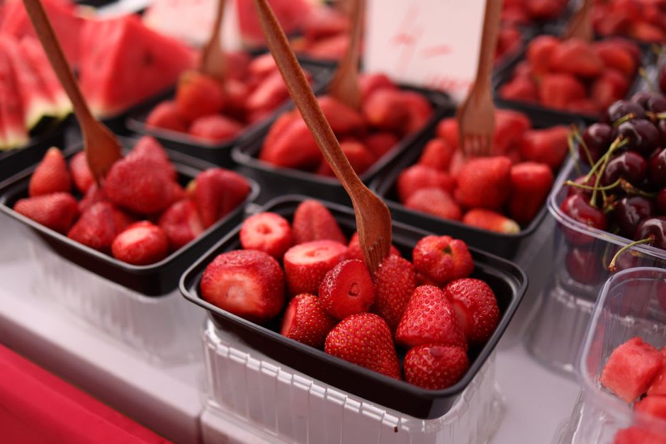 Puesto de fresas al borde de la carretera bajo sistema de honor en Jomala con cajas de madera de bayas y una pequeña caja de dinero