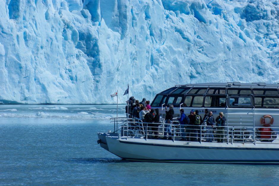 Small boat navigating between floating icebergs near a tidewater glacier terminus in Glacier Bay