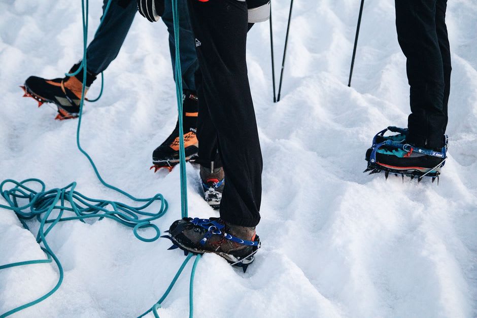 Excursionistas con crampones caminando sobre la superficie azul y agrietada del Glaciar Matanuska