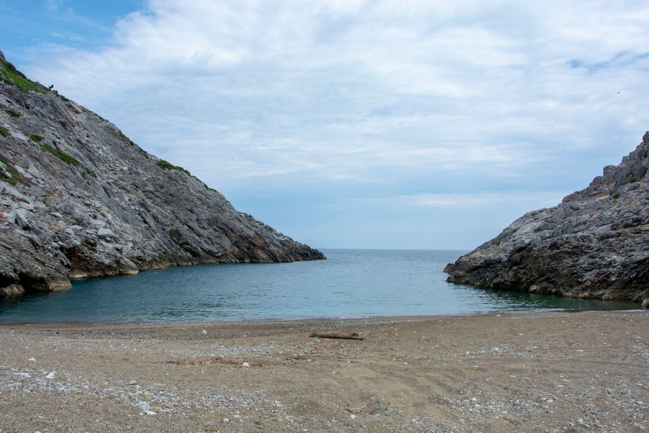 Una tranquila cala de guijarros al sur de la playa principal de Dhërmi con aguas turquesas transparentes