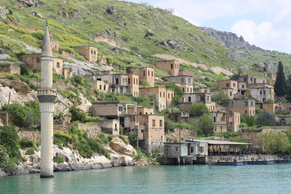The stacked stone houses of Himarë's old quarter climbing the hillside above the sea