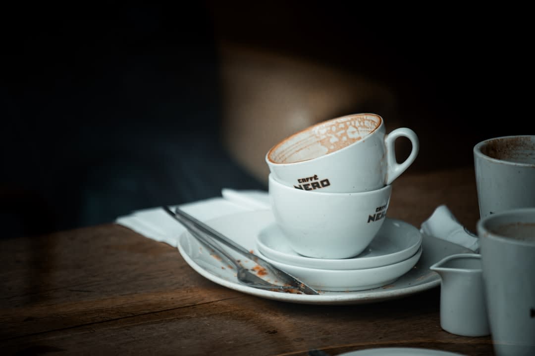 A steaming small cup of Albanian coffee on a café table in Korçë with the old bazaar visible outside
