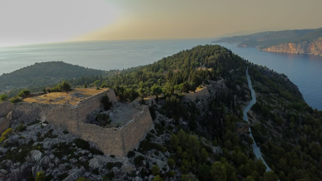 The stone ramparts of Krujë Castle overlooking the hazy coastal plain far below