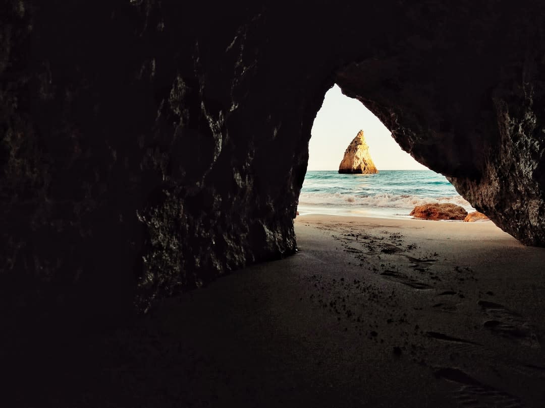 Kayak entering the narrow rock opening of Benagil Cave from the open sea