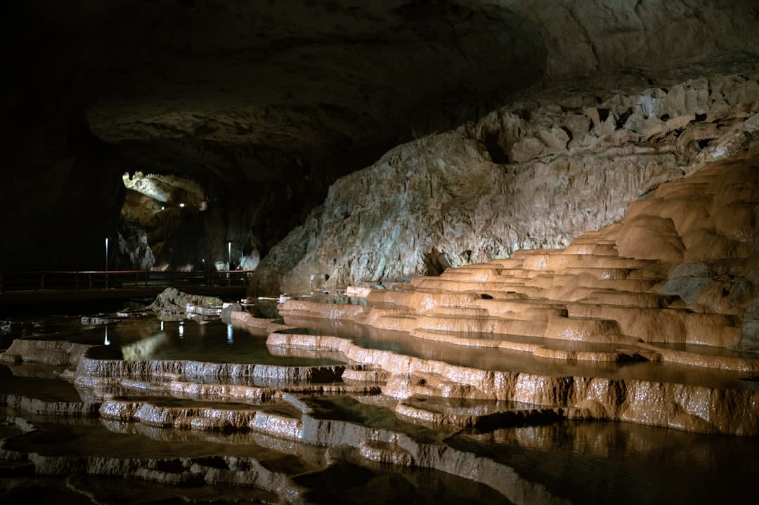 Sand floor of Benagil Cave lit by the circular opening in the cave's domed ceiling