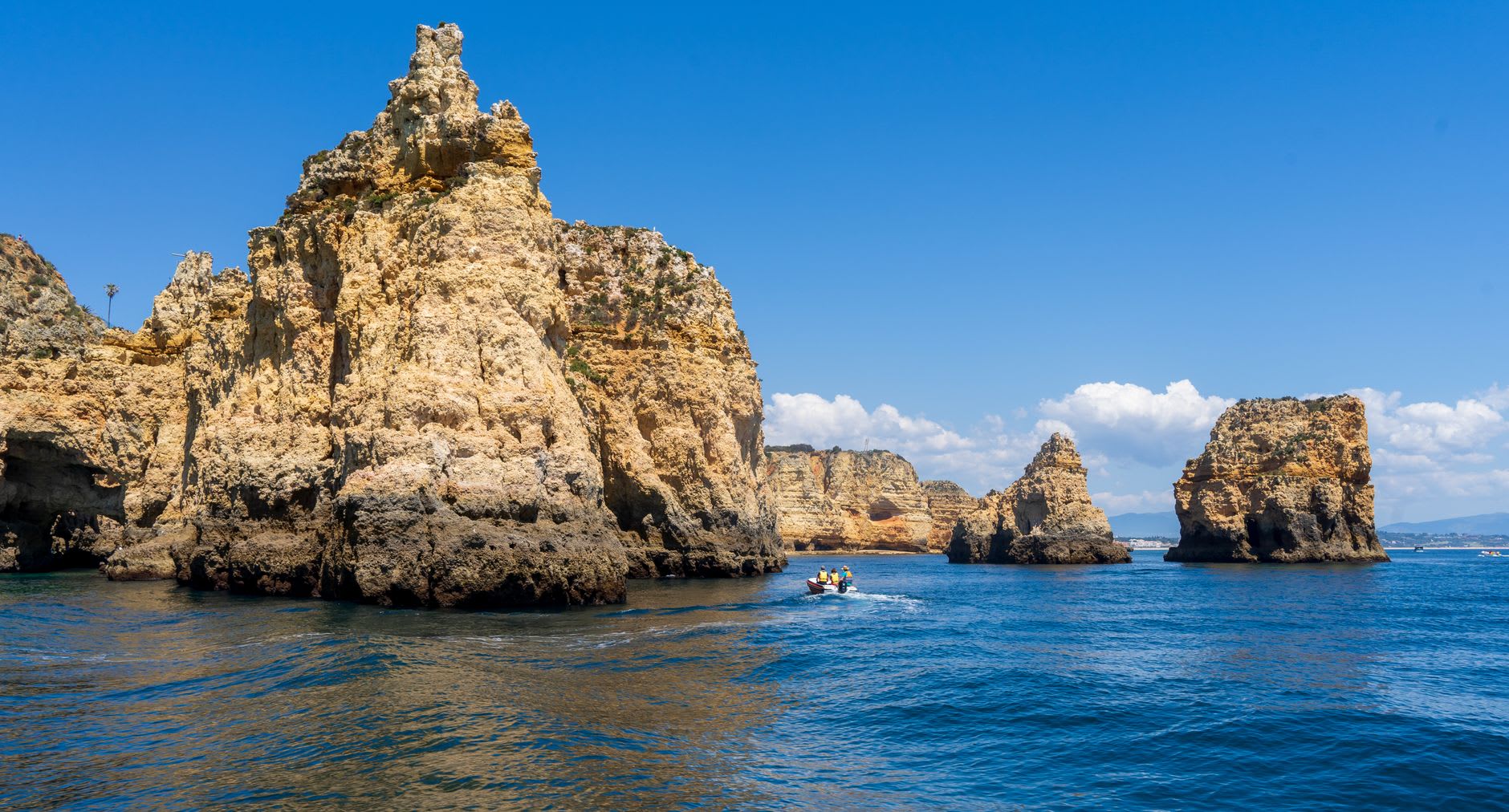 View from inside a Ponta da Piedade grotto looking out through the arch opening to turquoise Atlantic water