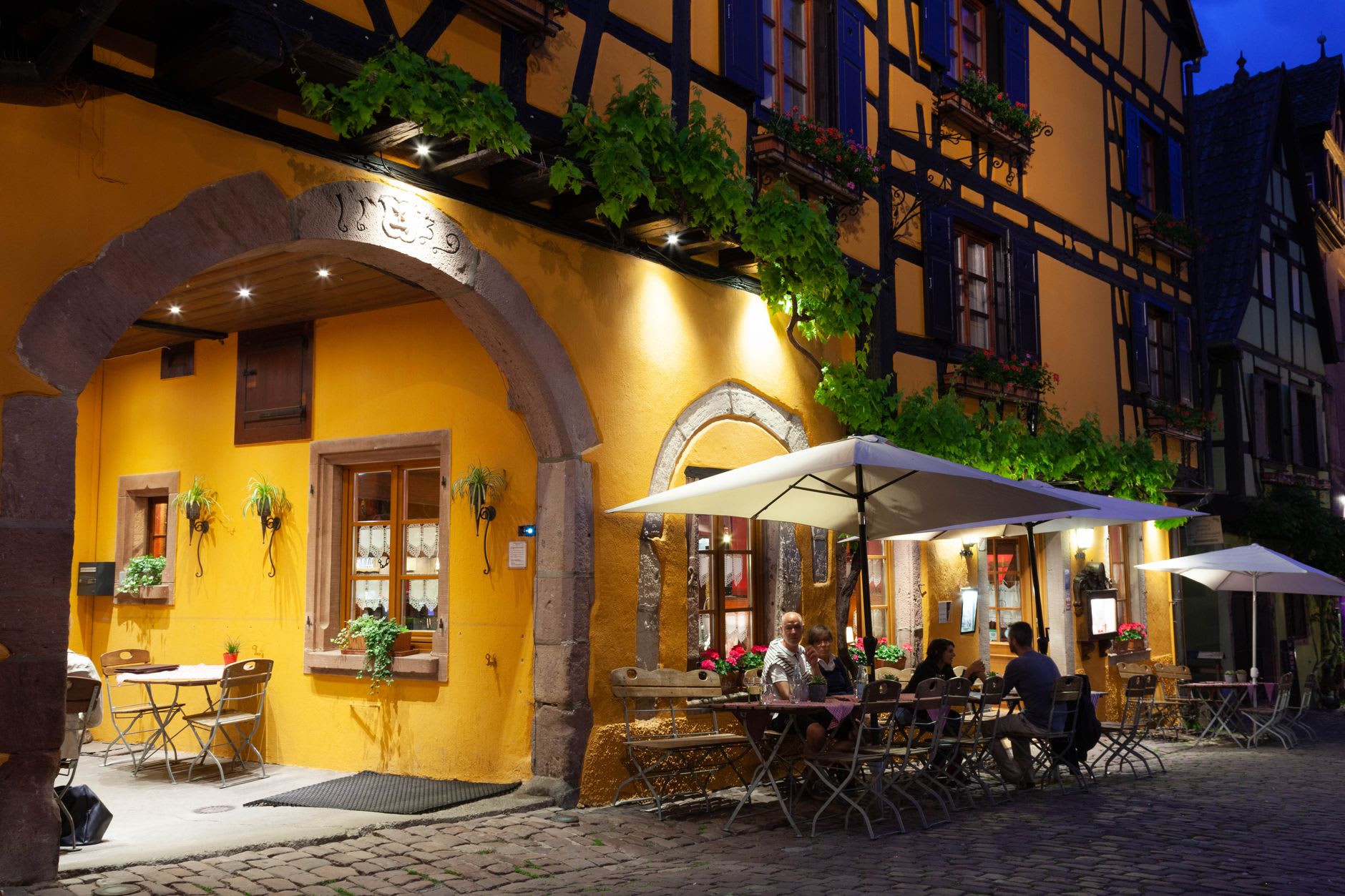 Riquewihr's main street with half-timbered facades and flower boxes on an autumn afternoon