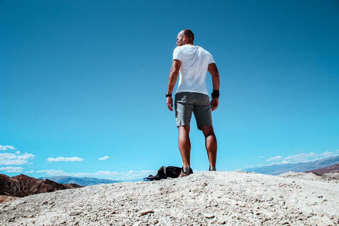 A traveler walking along a ridge in the striped valley toward second Mars