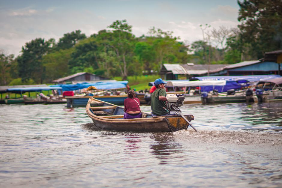 Wooden riverboats docked along Leticia's Amazon riverfront market at golden hour