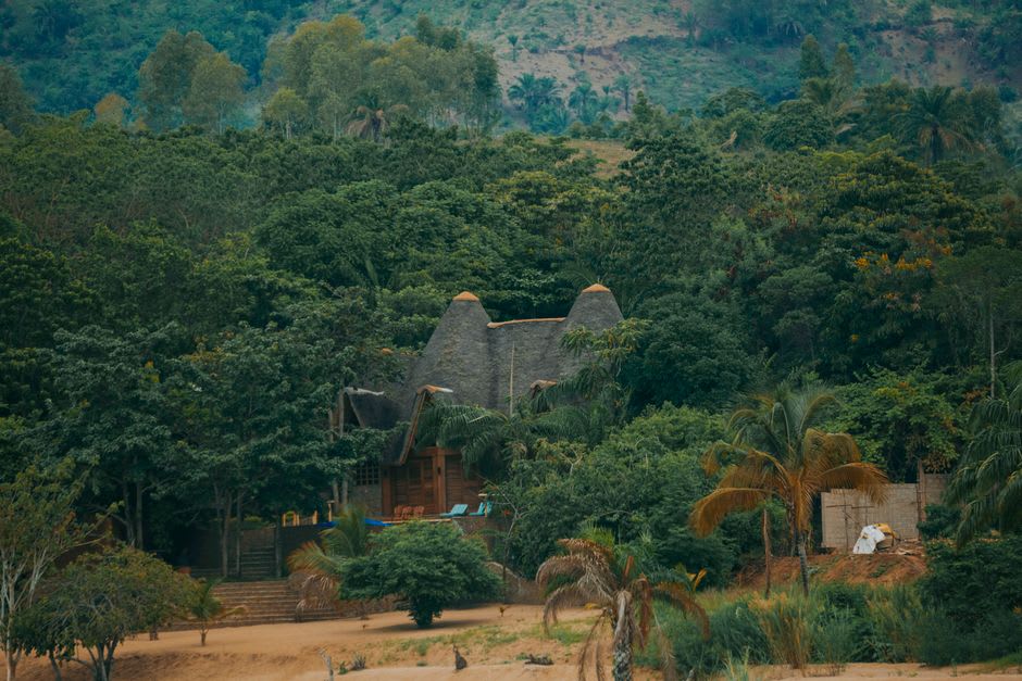 Thatched-roof stilted cabins of Kapawi Ecolodge reflected in the still waters of the Pastaza River