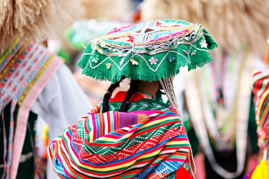 A woman in traditional Quechua Lamista dress weaving outside her home in the Wayku neighborhood of Lamas