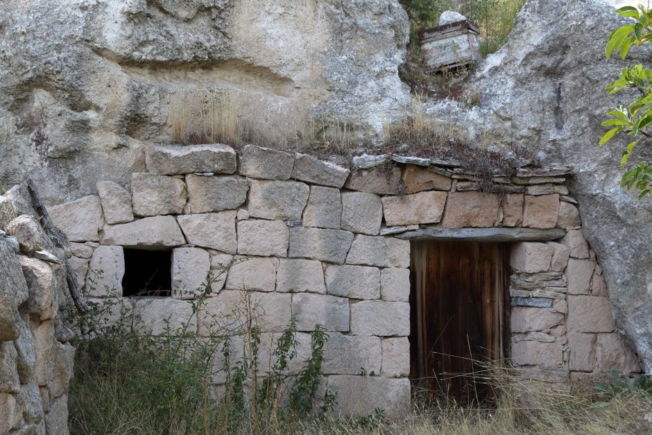 A narrow rock-cut passage in Kaymaklı with a rounded millstone door partially visible, used to seal the tunnel from within