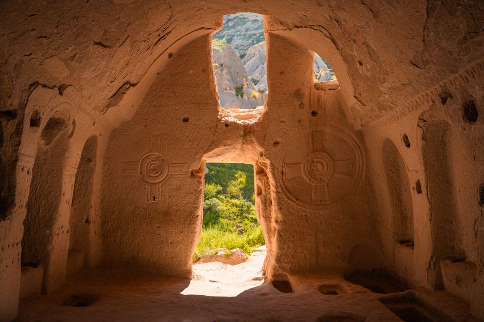 A rock-cut Byzantine church entrance in Soğanlı Valley, its facade weathered but still showing carved architectural details