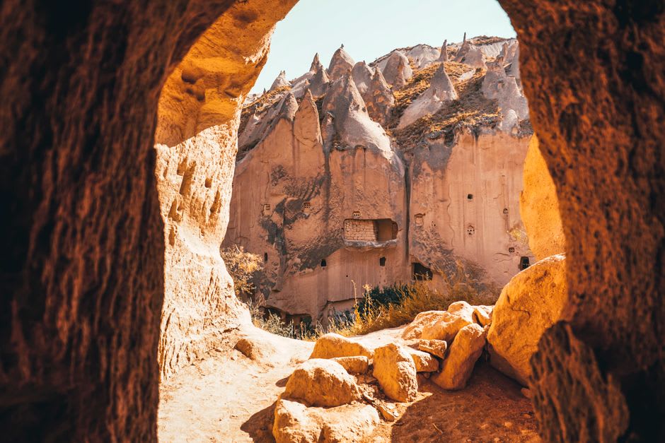 Un grupo de viviendas cónicas en chimeneas de hadas en el valle de Zelve, con sus puertas y ventanas talladas visibles en la roca volcánica erosionada