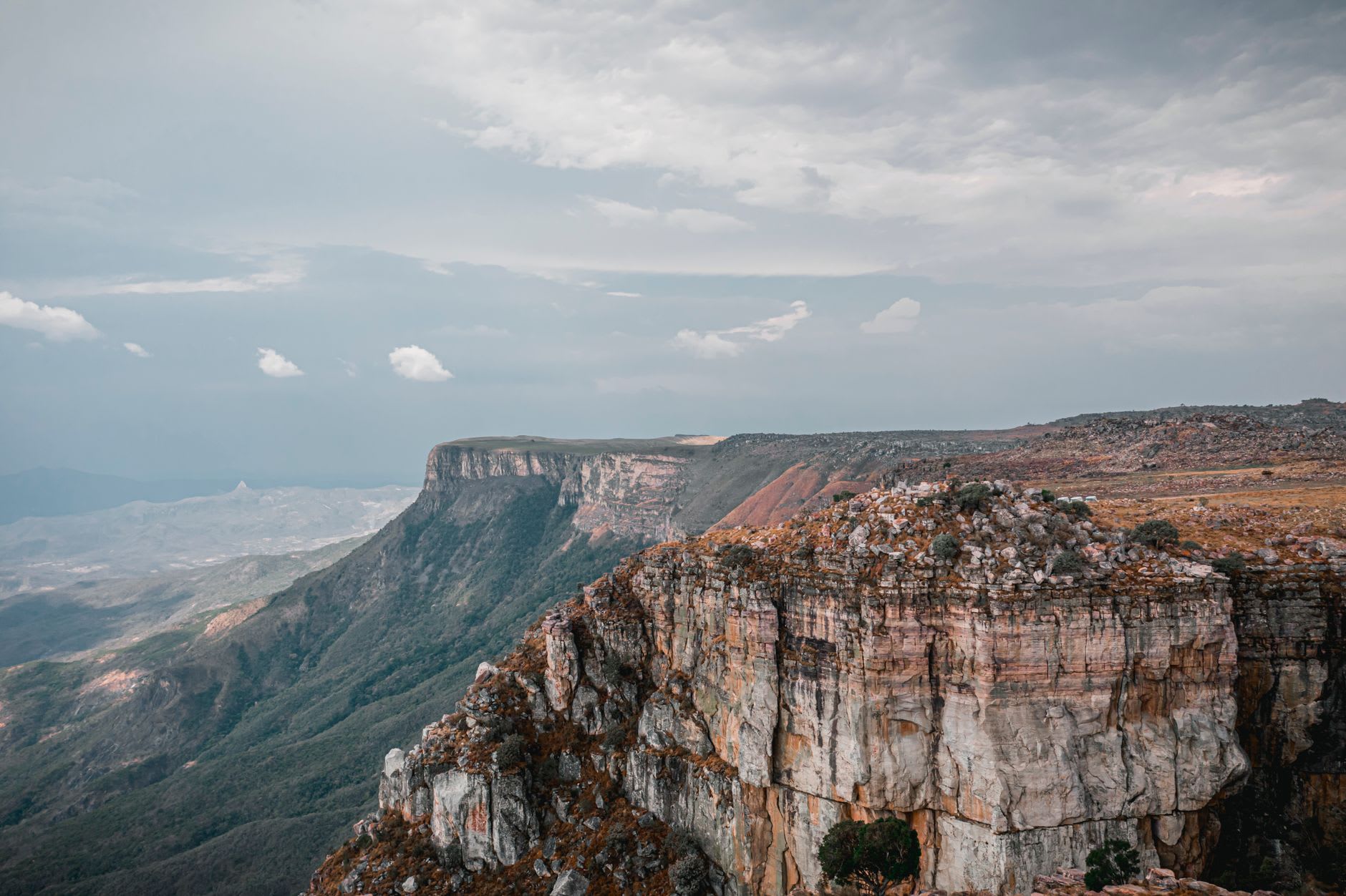 Looking down the face of the Tundavala cliff, the sheer rock face cutting away to the haze of the coastal plain far below