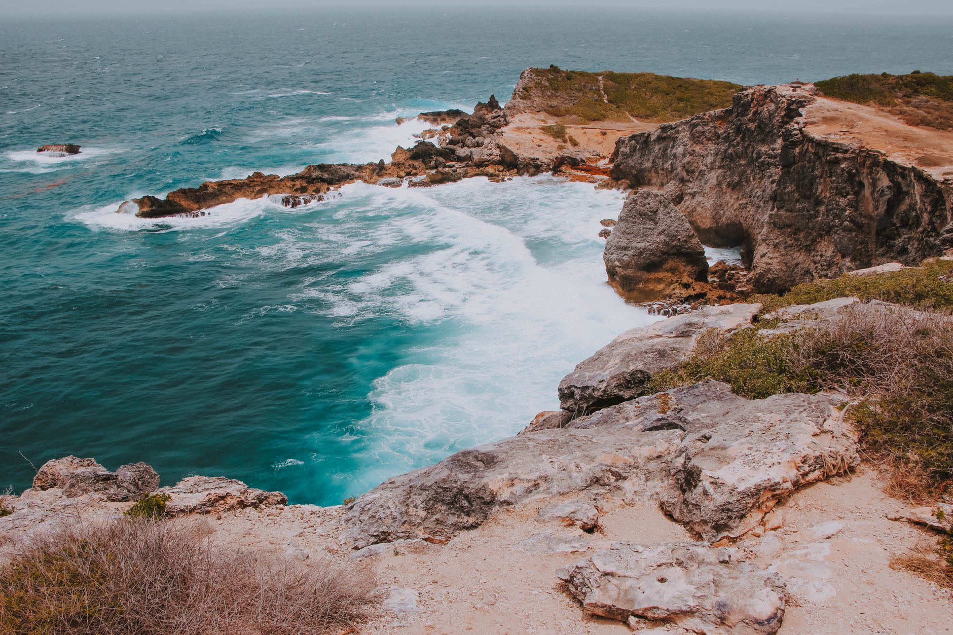 The view looking out from Little Bay's cove, turquoise water framed by limestone cliffs on either side
