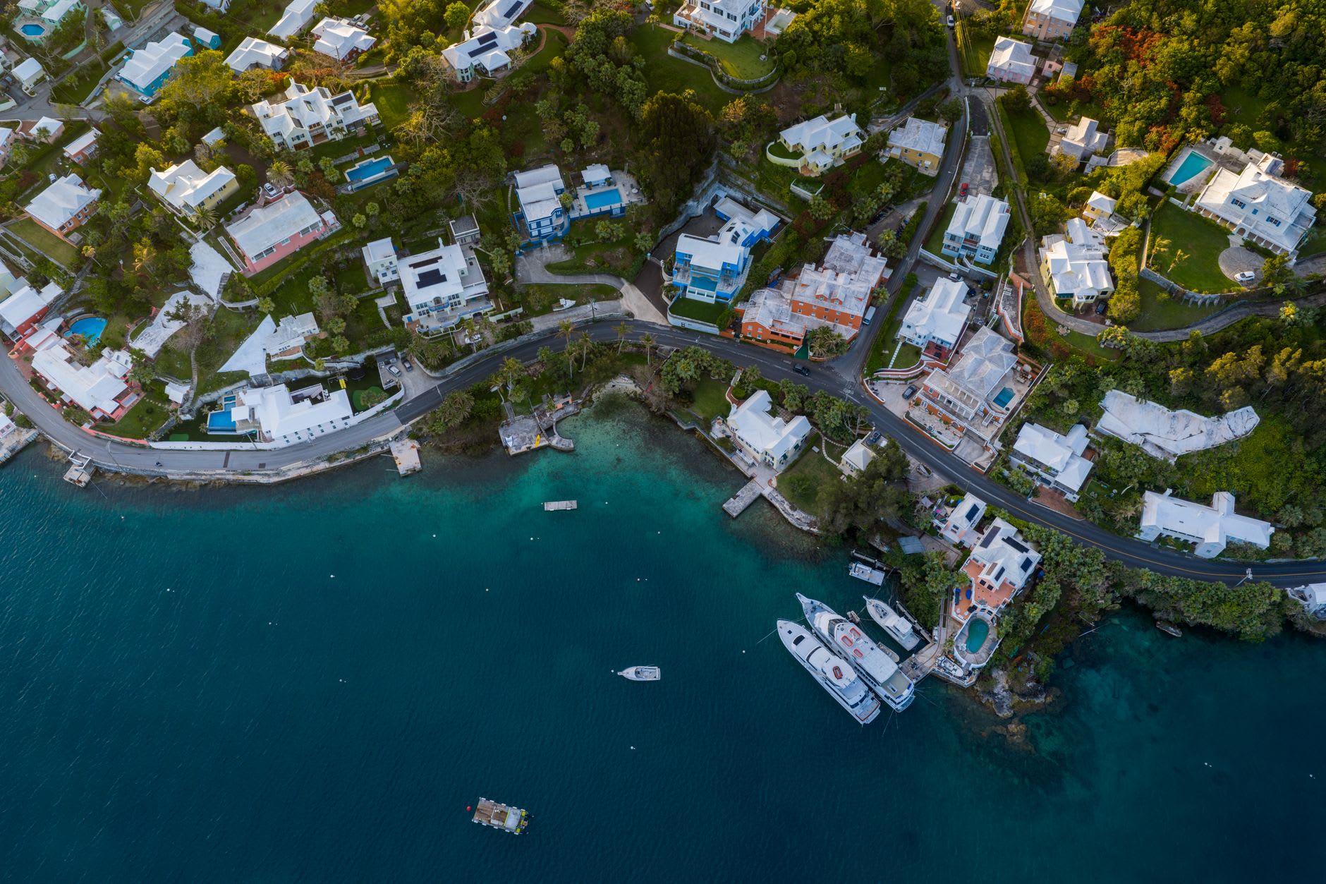 Sailboats moored at the marina in English Harbour with the green Antigua hills rising behind at dusk